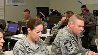 people in military unforms working on computers